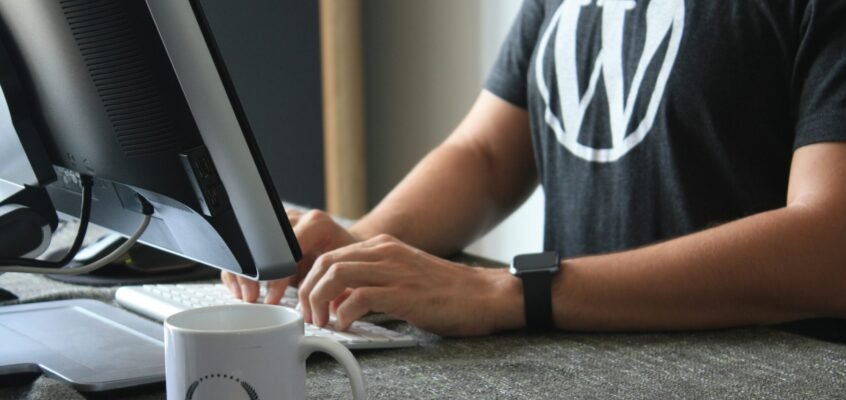 person in black and white t-shirt using computer